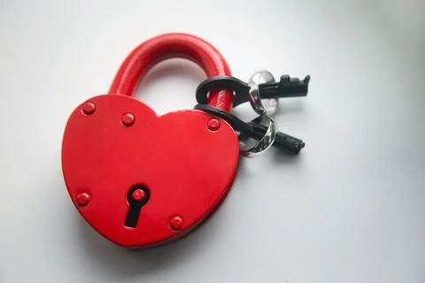 Red lock with keys and two wedding rings on a white background Foto stock