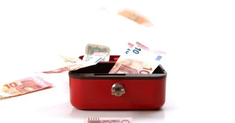Red lockbox with bank notes spilling out of it Stock Photos