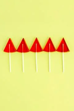 Red Lollipops in the shape of a triangle on a yellow background Stock Photos