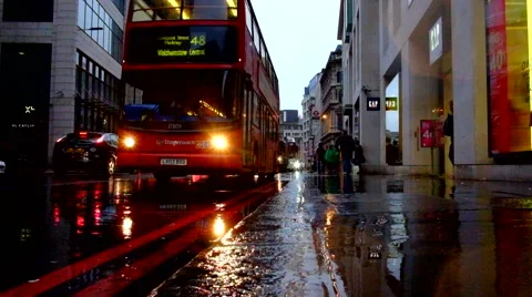 Red London bus passes in the rain Stock Footage