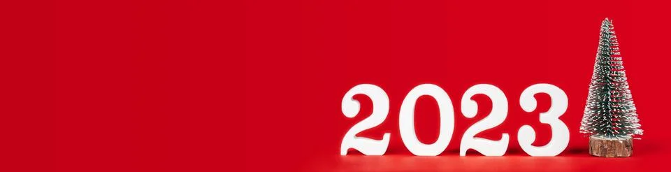 Red long rectangular banner with white wooden numbers 2023 stand with toy Stock Photos