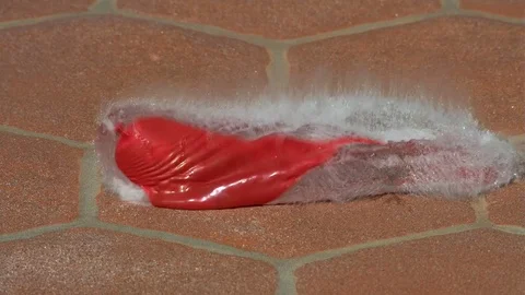 Red Long Water Balloon Fall Bounces and Explodes 2000fps Slow Motion Stock Footage 84076908