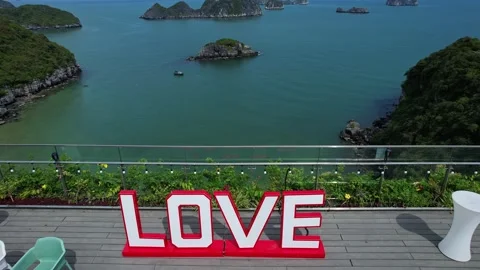 Red love sign on deck overlooking water, oasis of relaxation Cat Ba Halong Bay Stock Footage 274103784