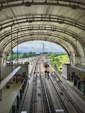 Red LRT train approaching a modern elevated arched station Stock Photos