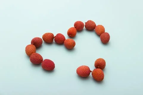 Red lychee heart shape on blue White Background.Valentines Day symbol Made of Stock Photos