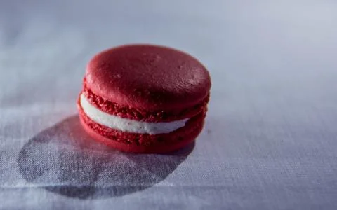 Red macaroon on a white fabric background in the light of lamps. beautiful bo Stock Photos
