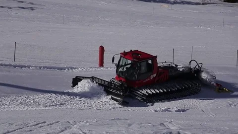 Red machine for skiing slope preparations in Austrian Alps at background of Stock Footage 77146475