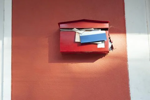Red mailbox with documents overflowing Foto stock