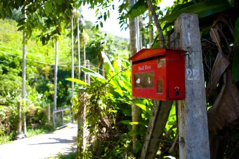 The red mailbox is fixed to the post. Stock Photos