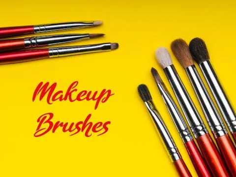 Red makeup brushes on yellow background Stock Photos