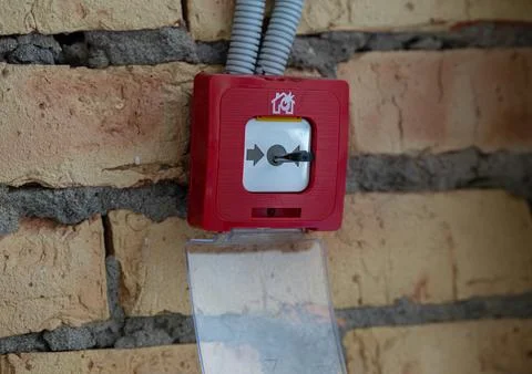 Red manual call point fire alarm button with an open protective cover Fotos de archivo