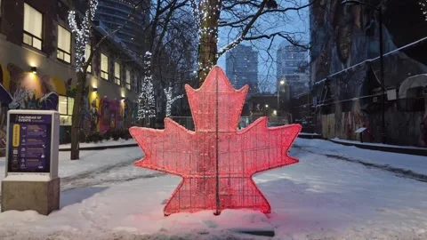 Red maple leaf light installation glowing in downtown Toronto, winter snow Stock Footage 327992739