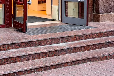 Red marble staircase with granite steps to entrance door. Stock Photos