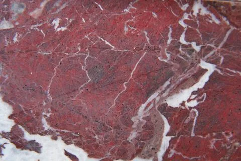 Red marble stone shows patterns and textures in detail Stock Photos