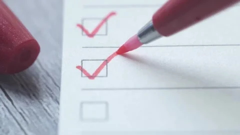 Red marker checking boxes on white paper close up, making checklist and mar.. Stock Footage 332627074