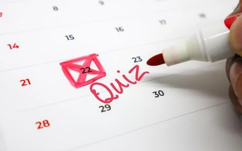 Red marker hand annotates a personal calendar, highlighting a quiz date and.. Stock Photos