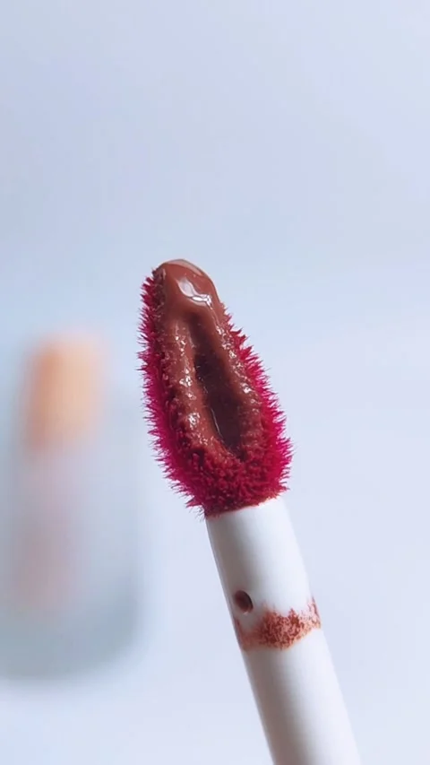 Red maroon lipstick brush with white handle in vertical close up. Isolated .. Stock Footage 340629427
