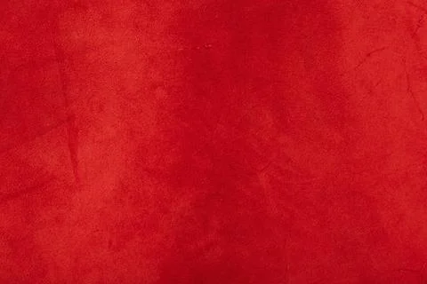 Red matte background of suede fabric, closeup. Texture of seamless leather. Stock Photos