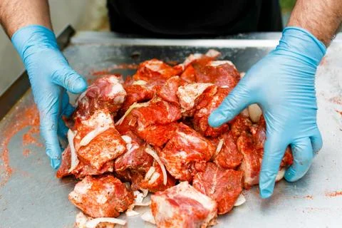 Red meat is mixed in a barbecue marinade. Stock Photos