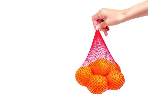 Red Mesh Bag of Fresh Oranges in Hand 스톡 사진