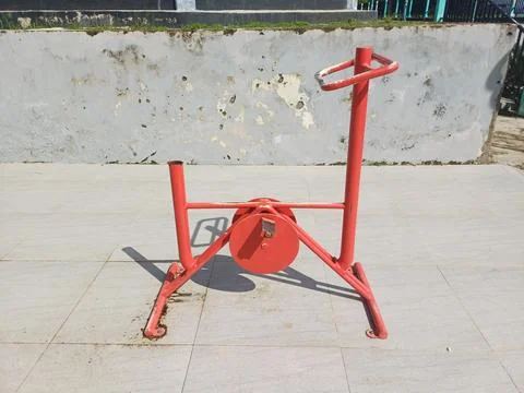 Red Metal Frame of an Old Exercise Bike Outdoors on Concrete. Stock Photos