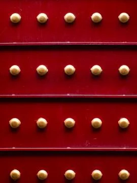 Red Metal Panel with Golden Rivets in Grid Pattern, Vintage Industrial Textur Stock Photos