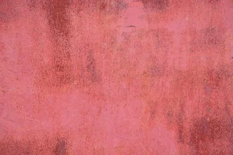 Red metal surface with uneven rust spots and peeling old paint Stock Photos