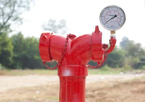 Red metallic fire hydrant with pressure gauge or fire department connection o Stock Photos