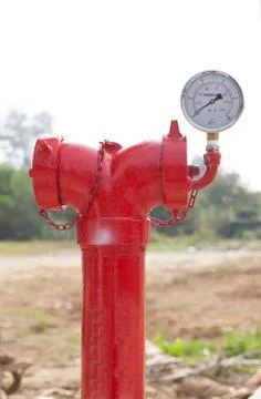 Red metallic fire hydrant with pressure gauge or fire department connection o Stock Photos