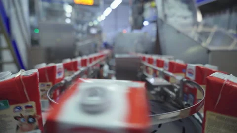 Red Milk Cartons are progressing through a production conveyor line at a factory Stock-Footage 169988218