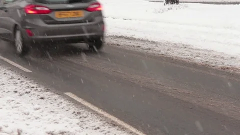 Red Minivan Drives Through Slush in Snowy Conditions 库存影片 83275651