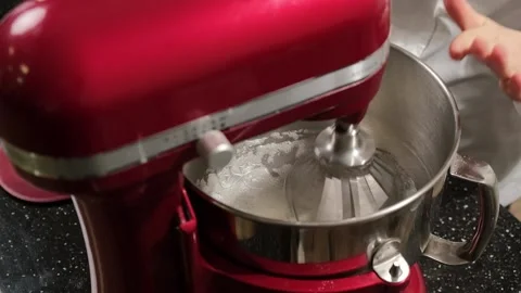 Red mixer which is whipping the egg whites in a stainless bowl in the kitchen. Stock Footage 149595028
