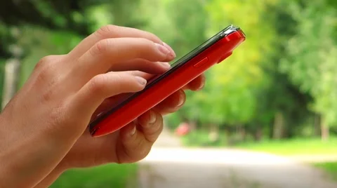 Red mobile phone in a park Stock Footage 41644459