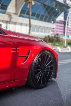 Red model sedan in the landmark parking, front wheel view Stock Photos
