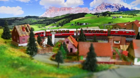 Red model toy train in miniature. Model railway. Mountains ambientation. Stock Footage 228219948