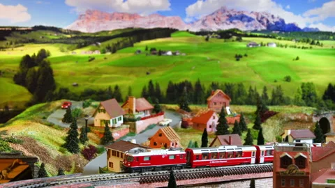 Red model toy train in miniature. Model railway. Mountains ambientation. Stock-Footage 228221022