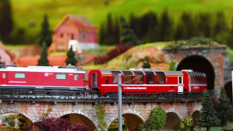 Red model toy train in miniature. Model railway. Mountains ambientation. Stock Footage 228227040