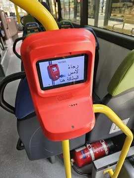 Red, modern ticket validator with a digital screen showing an Arabic message Stock Photos