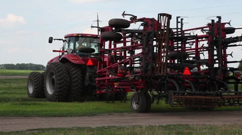 Red modern tractor with trailed harrow, out in an agricultural field to cultivat Stock Footage 38287294
