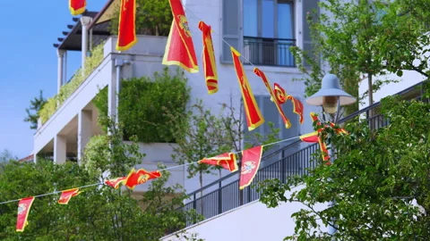 Red Montenegrin flags with golden eagle waving on ropes across a street Vídeos de archivo 339061582