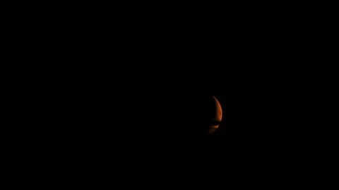 Red moon in a dark night cloudy sky close up 動画素材 200413185
