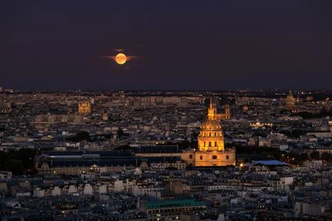 Red moon over the tower of Les Invalides museum in Paris, night time Stock Photos