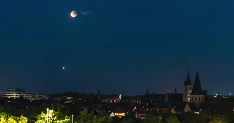 Red moon rises above Mechelen cityscape, time lapse view Stock Footage 317756722
