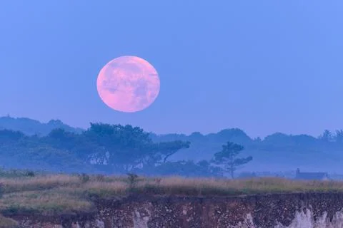 Red moon setting over high cliffs near Ault Stock Photos
