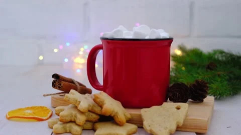 Red mug of cocoa, ginger biscuits, and garlands on a light background. Stock Footage 164866794
