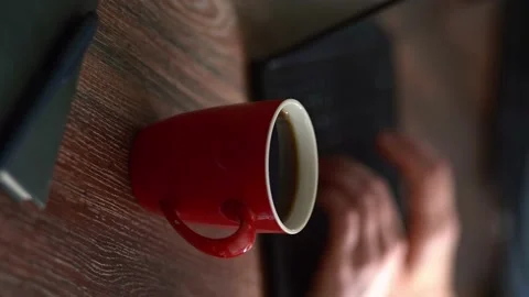 A red mug of steaming coffee. Working atmosphere. Stock Footage 154935202