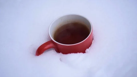 Red mug of steaming hot tea Buried in  snow. Stock-Footage 114379233