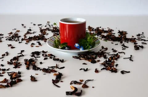 Red mug on a white table with leafs and flowers and white background Stock Photos