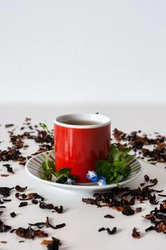 Red mug on a white table with leafs and flowers and white background Stock Photos
