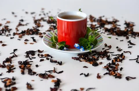 Red mug on a white table with leafs and flowers and white background Stock Photos